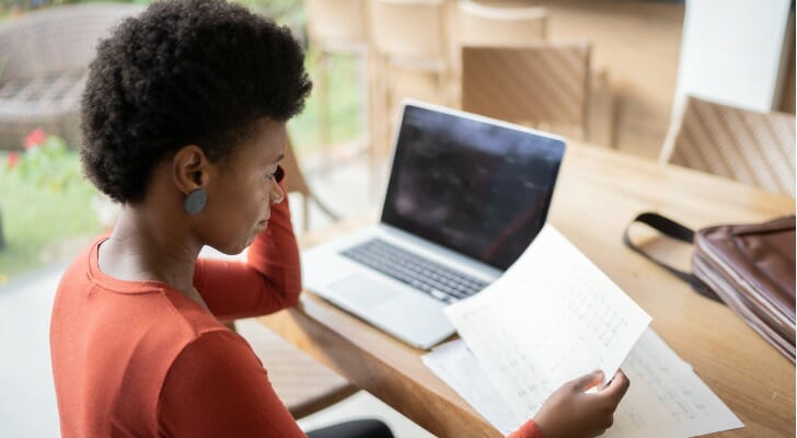 A woman deciding whether to use a financial advisor vs. self investing.
