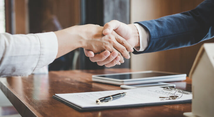 Buyer and seller shaking hands on a business sale.
