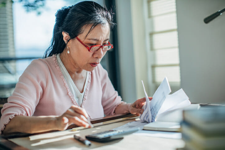 A woman calculating the interest on her savings.