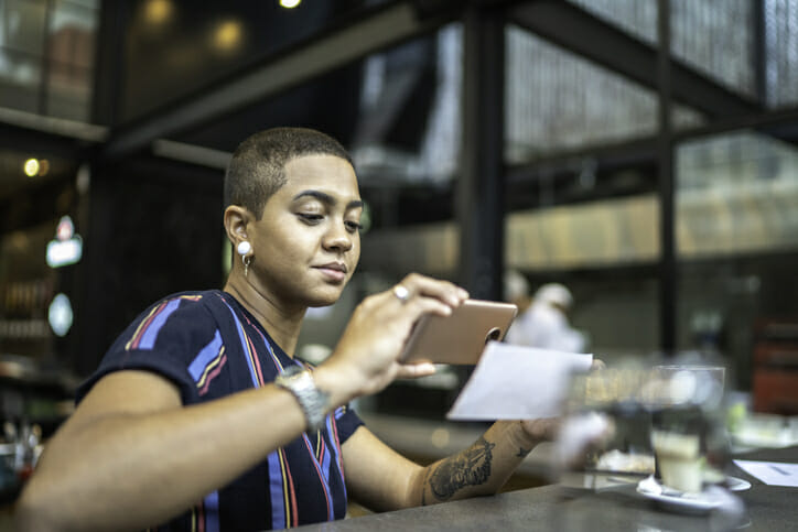 A woman depositing her check with a mobile phone.