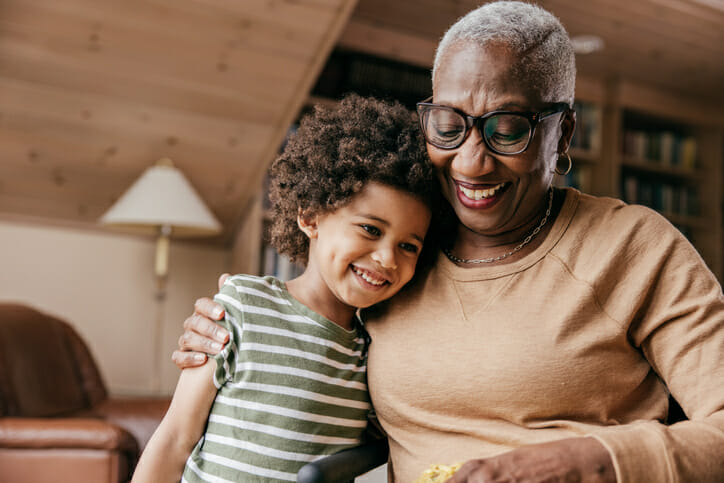 A grandmother hugging her grandchild after setting up a savings account.