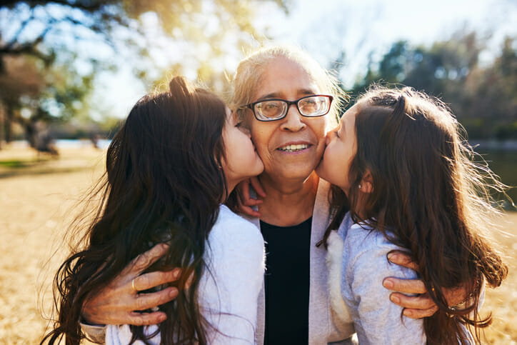 Twins kissing their grandmother after she opened savings accounts for them.