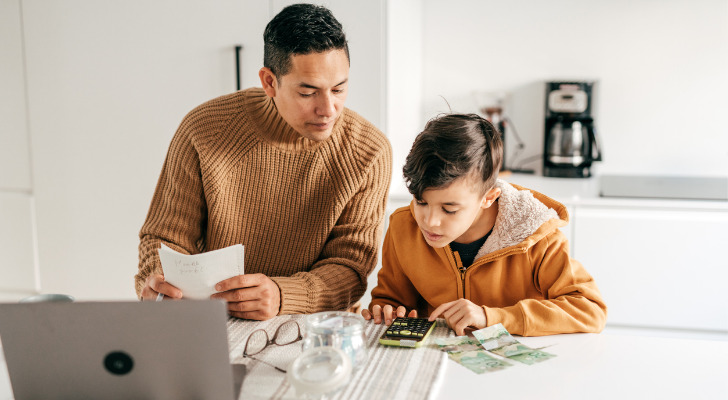 A father looks up how to open a savings account for a child with his son.