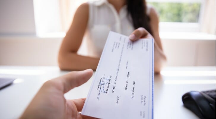 A client getting a check from a bank teller.