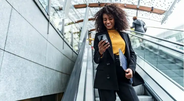 A woman checking her bank account on a mobile phone.