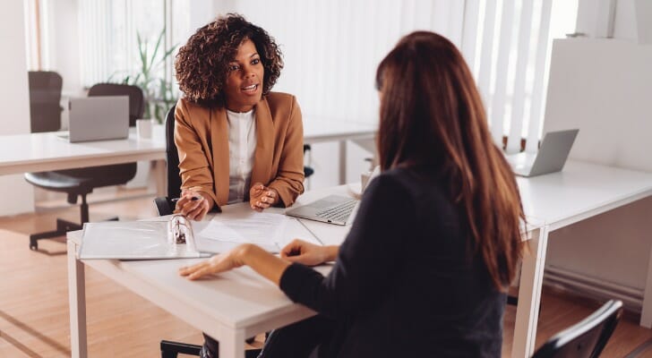 A woman and her advisor discuss prize linked savings accounts.