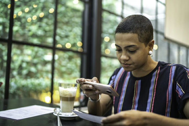 A woman uses a mobile banking app to deposit a check.