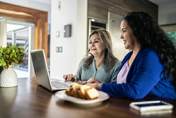 Two women looking up different rates for term deposits.