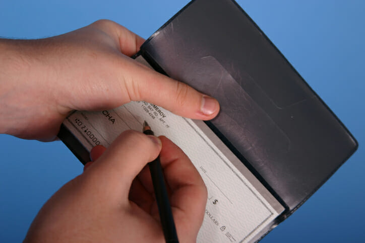 A person filling out a check.