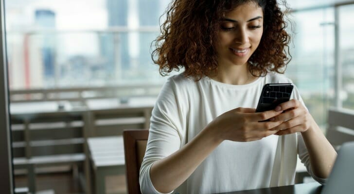 Closeup of a woman looking up the status of a bank transfer.