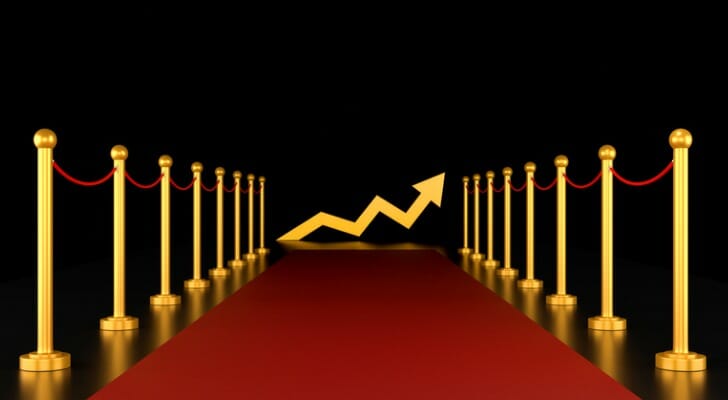 Image of a movie red carpet premiere with an arrow stock market chart symbolizing investment opportunities.