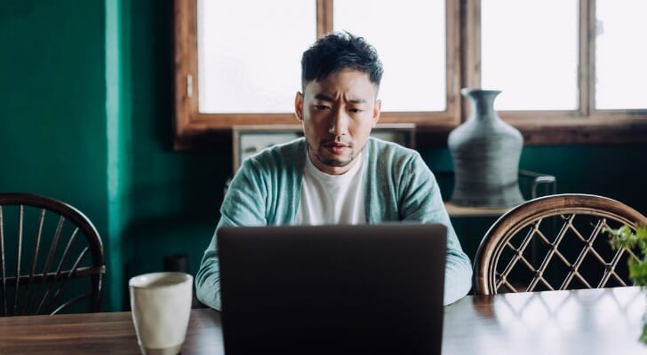 A man comparing the pros an cons of money market vs. checking accounts.