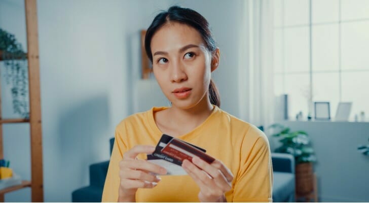 A woman comparing different debit cards from her bank accounts.