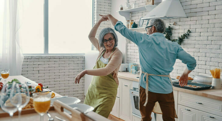A retired couple dancing in the kitchen.