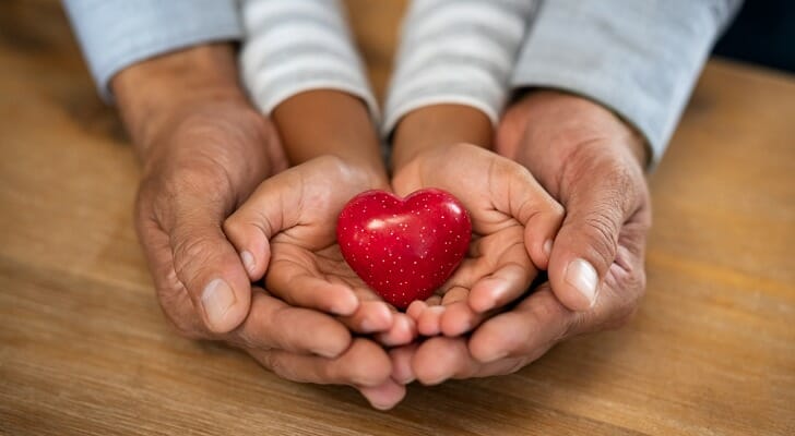 Man and child holding a red heart