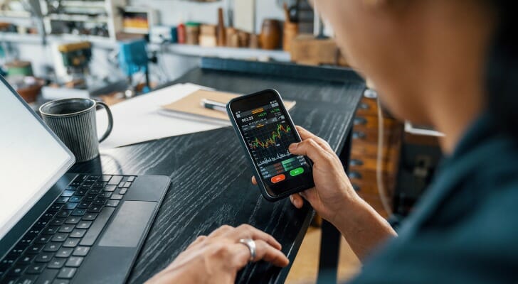 An investor checks his portfolio on his phone. Research from Dimensional Fund Advisors points to the long-term benefits of diversification.
