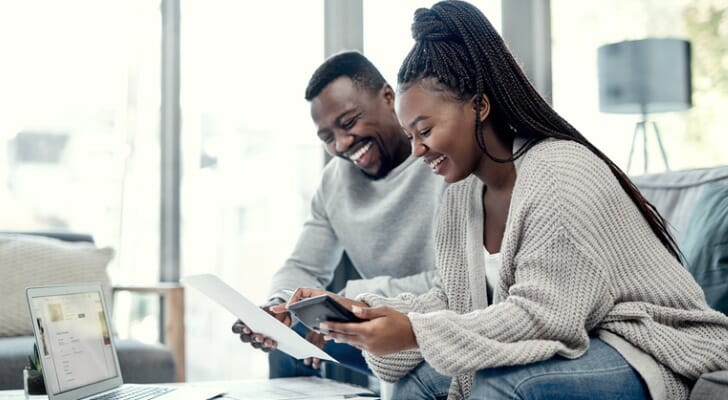 A couple checks on their investments together. Research from Dimensional Fund Advisors points to the long-term benefits of diversification within a portfolio.