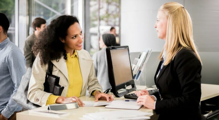 A bank teller assists a customer.
