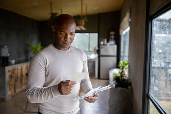 A man reading a bank note explaining why checks are being held.