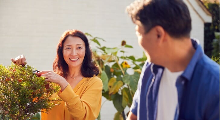 A couple work in their garden, talking about whether $5 million is enough to retire at 55.