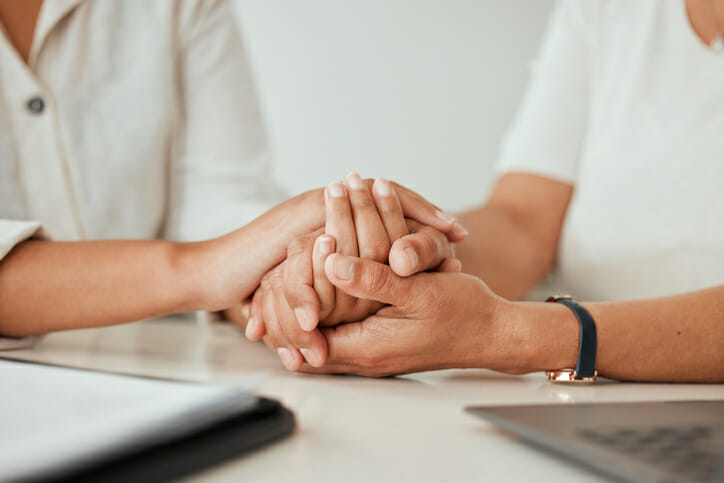 A mother and daughter holding hands after creating a trust.