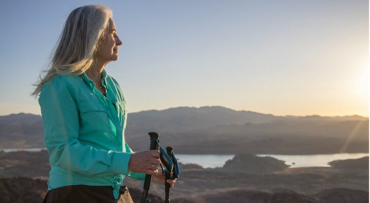 A woman hiking, having retired at 55 with $5 million.