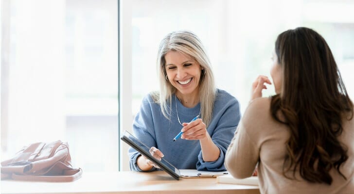 Two financial advisors discussing client acquisition strategies.