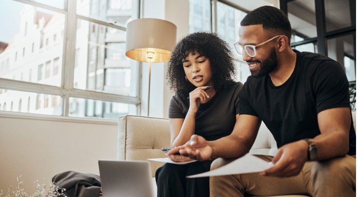 A couple comparing the benefits and drawbacks of checking and savings accounts.