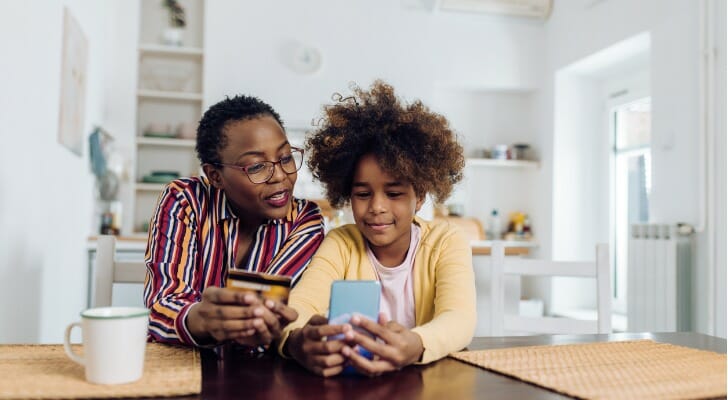 A mother teaches her daughter about banking.