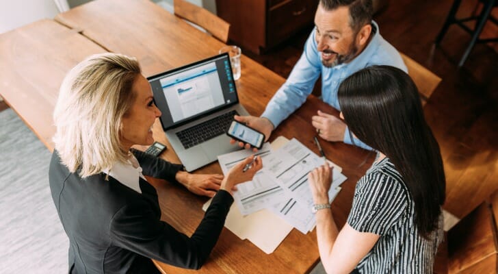 A couple ask their financial advisor if checking accounts earn interest.