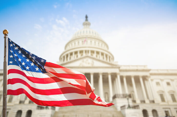 The American flag waves in front of the U.S. Capitol building.