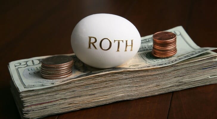A white egg with the word "Roth" printed on the shell, sitting on top of cash in between coins.