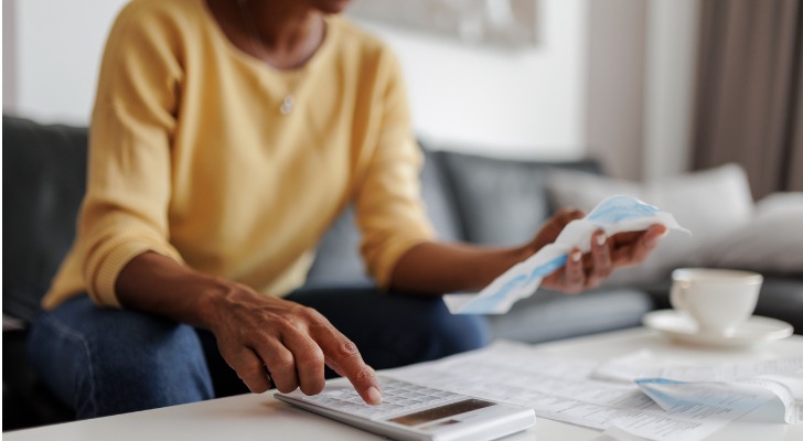 A woman calculating how much her account will grow.
