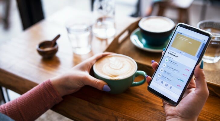 A woman reviewing her bank account on her mobile phone.