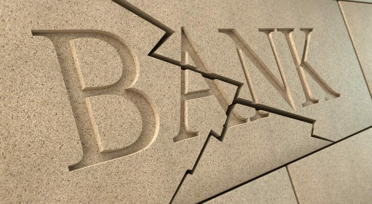 A wall engraved with the word "bank," with cracks running through it.
