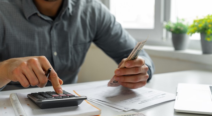 A man calculating how to make $500 a month in passive income.