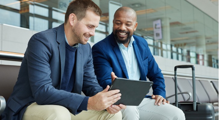 Man showing his friend how his large sum investment is doing.