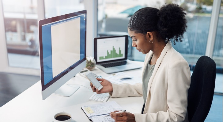 A financial advisor takes notes as she looks over a client's investment portfolio.