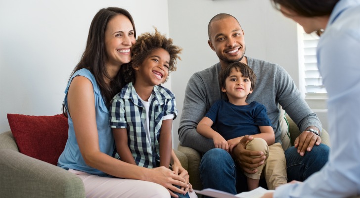 Husband, wife and children talk with an agent about insurance.