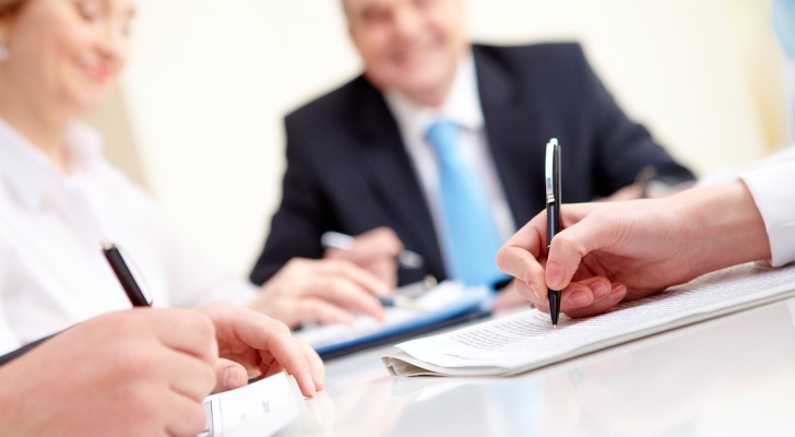 Notary providing services watches signatures and asks for payment.