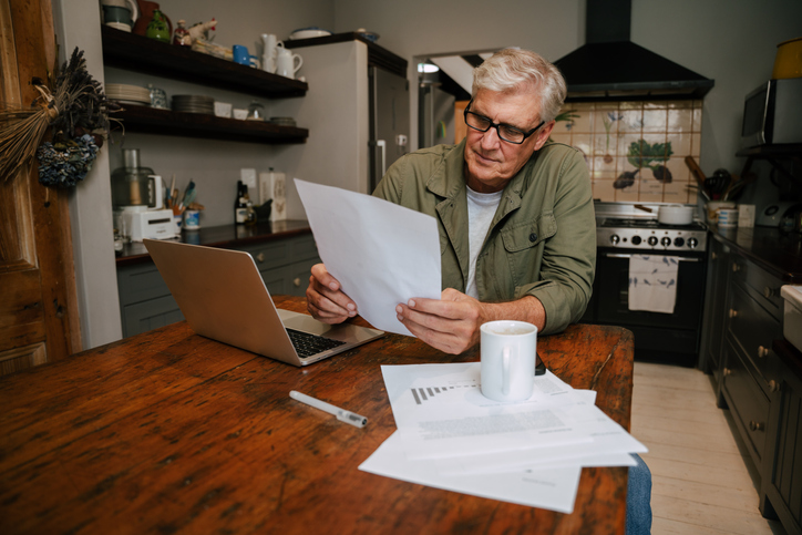 A retiree who does freelance consulting works at his kitchen table.