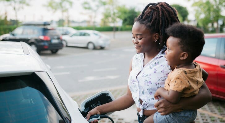 A woman charges her new electric vehicle.