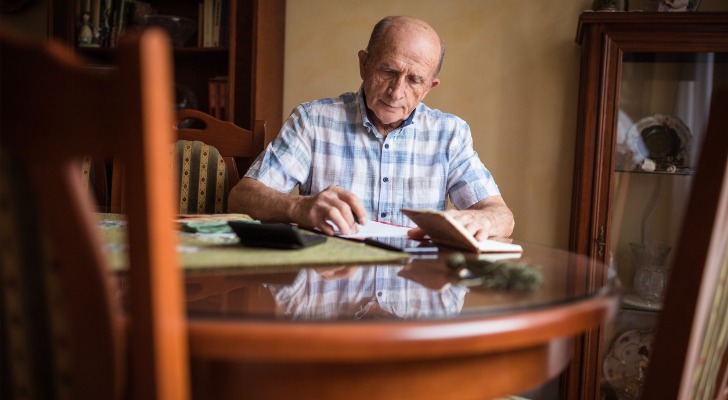 Elderly man calculating how much Medicare costs.