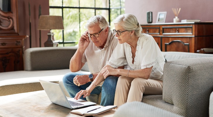 A married couple calculates their RMDs together on a laptop computer.