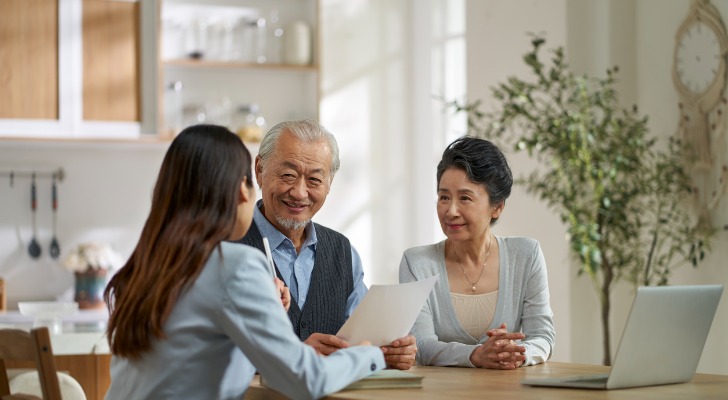 Senior Asian couple discussing their retirement savings plan with their financial advisor.