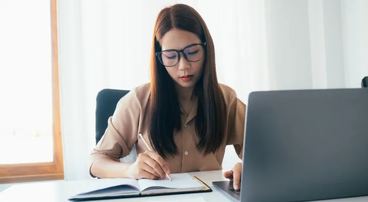 A woman calculating whether she is receiving a 10% return on her investment portfolio.