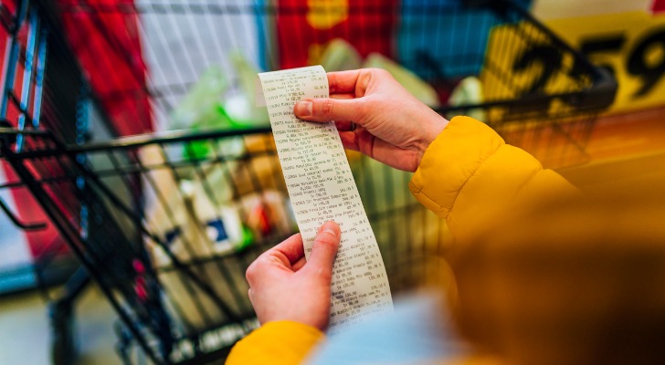A woman looking at her discretionary expenses at the grocery store.