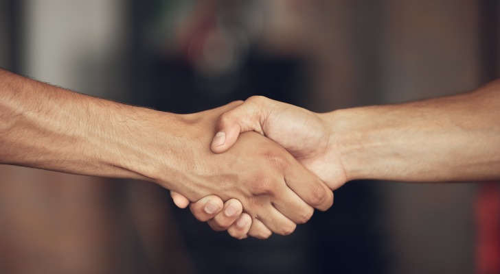 Mortgage lender and home buyer shake hands.