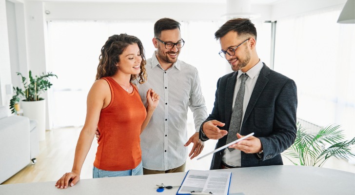A realtor going over the sales contract on a new investment property that was purchased with no money down.