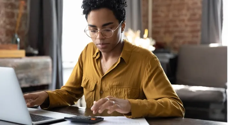 A woman calculating how much she will make in dividends if she invests her $100,000.